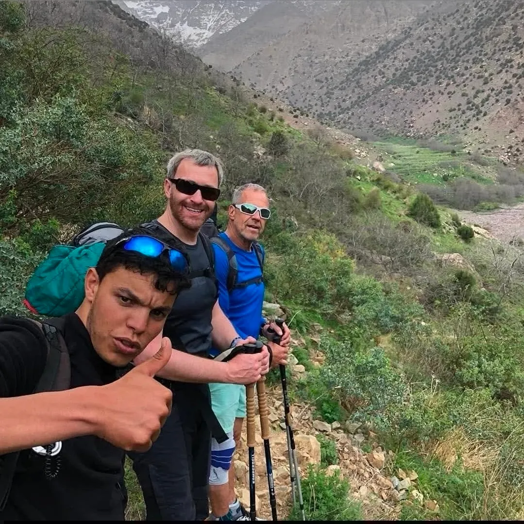 Omar leading trekkers through a green High Atlas valley
